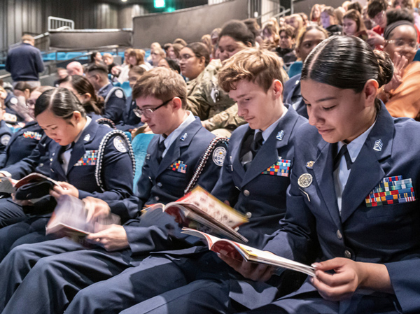 kcrepgroups2 Students dressed in military uniforms sit in Spencer Theatre, reading a show program